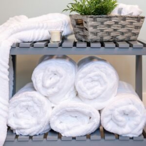 White towels rolled and stacked by the bath