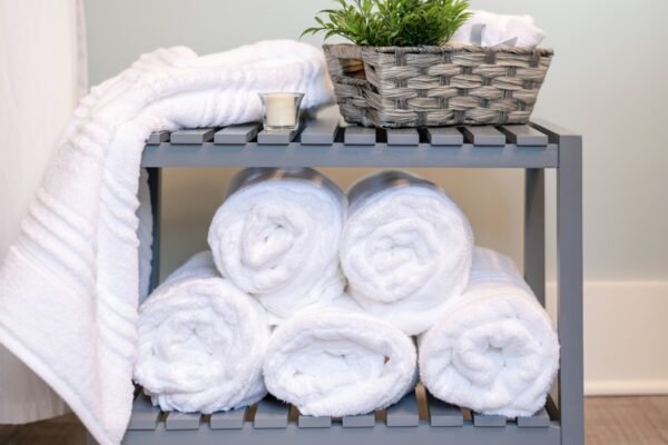 White towels rolled and stacked by the bath